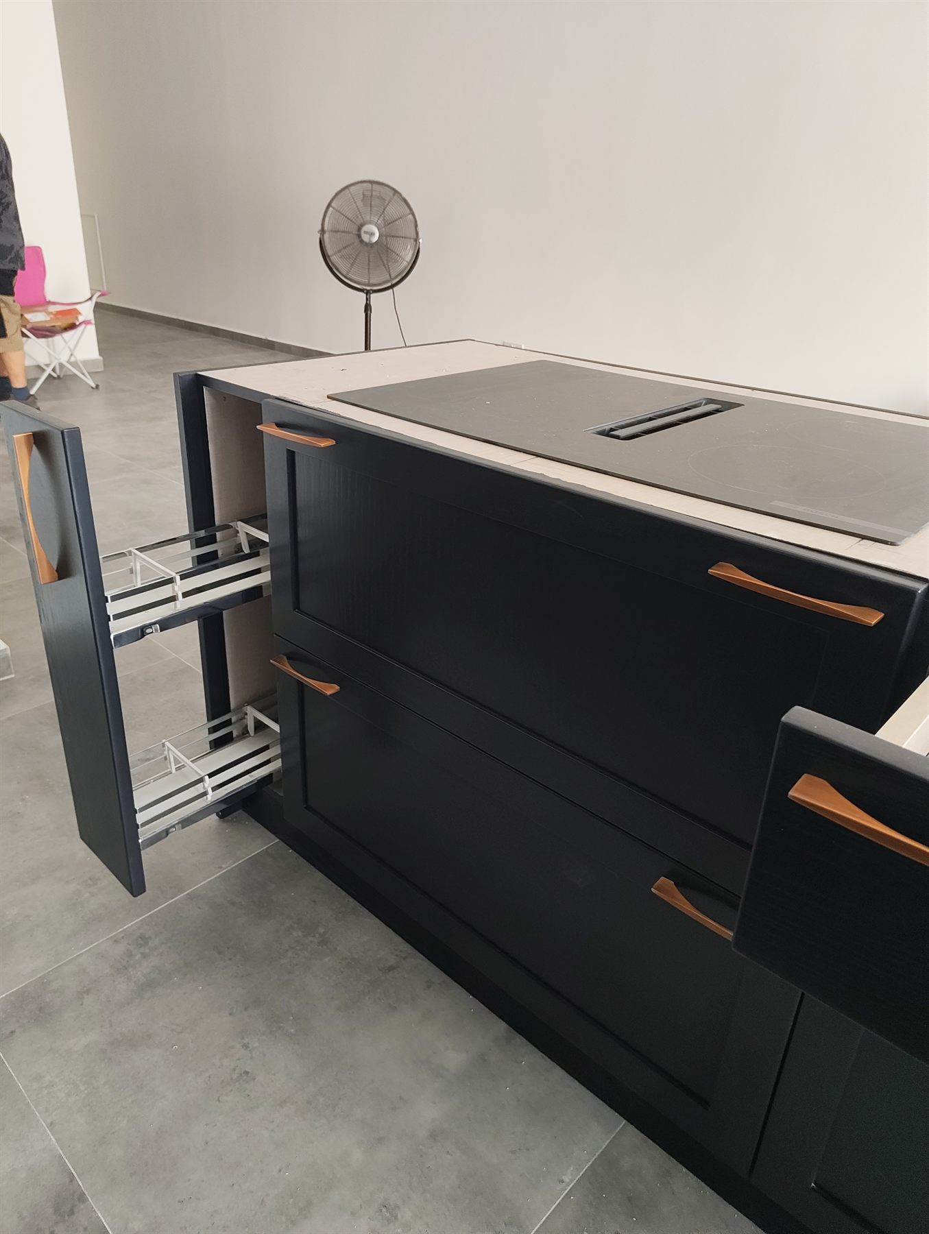 Black kitchen island with induction hob and copper handles