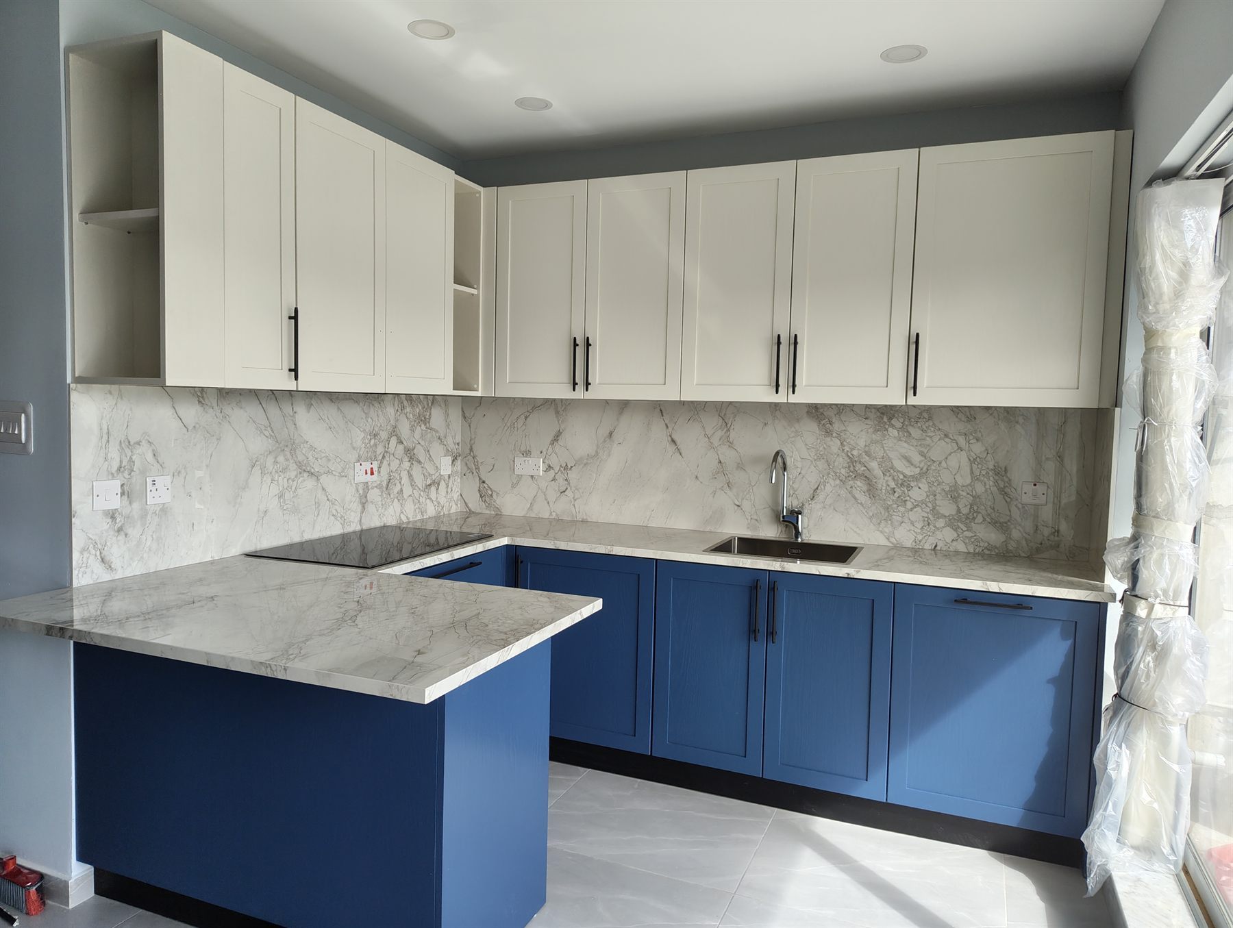 Navy blue shaker kitchen with marble worktop