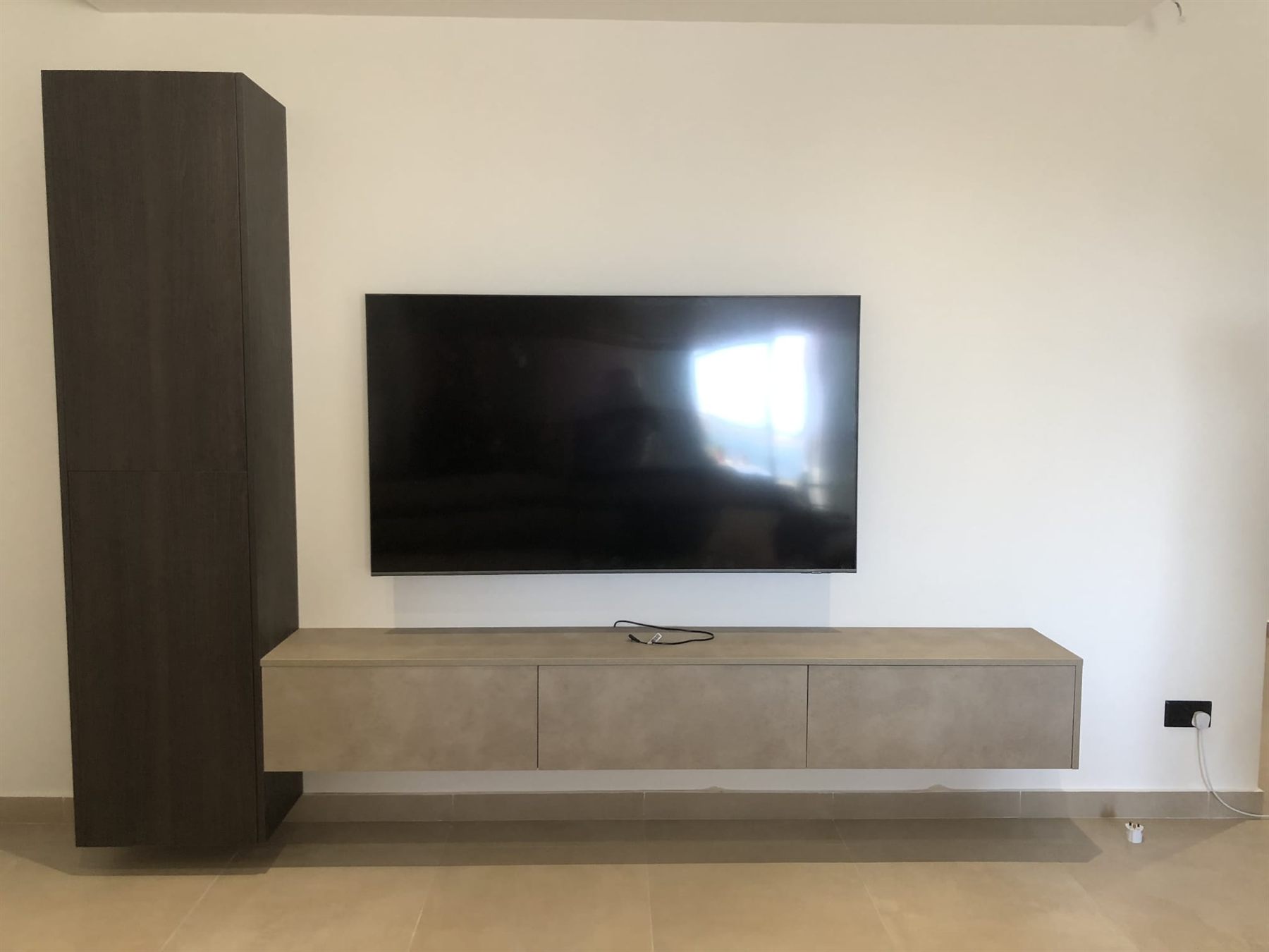Floating concrete-effect TV unit with tall dark oak cabinet