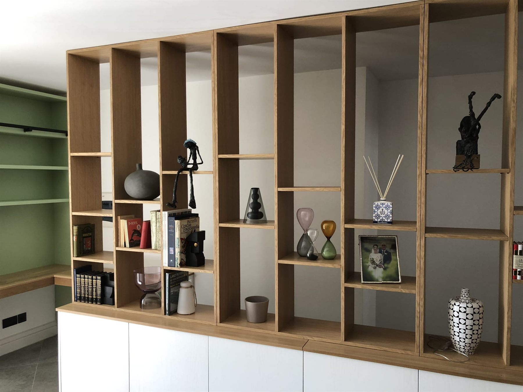 Floor-to-ceiling oak open shelving with white base cabinets
