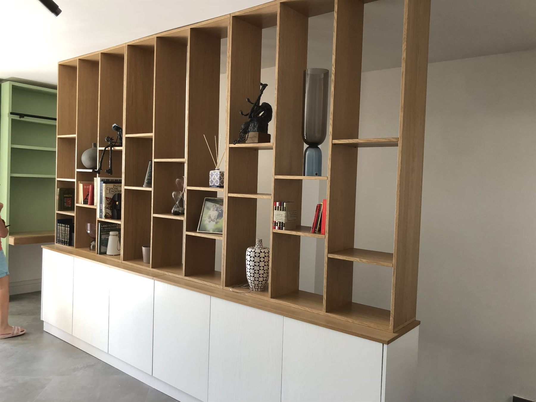 Oak shelving room divider styled with books and ornaments
